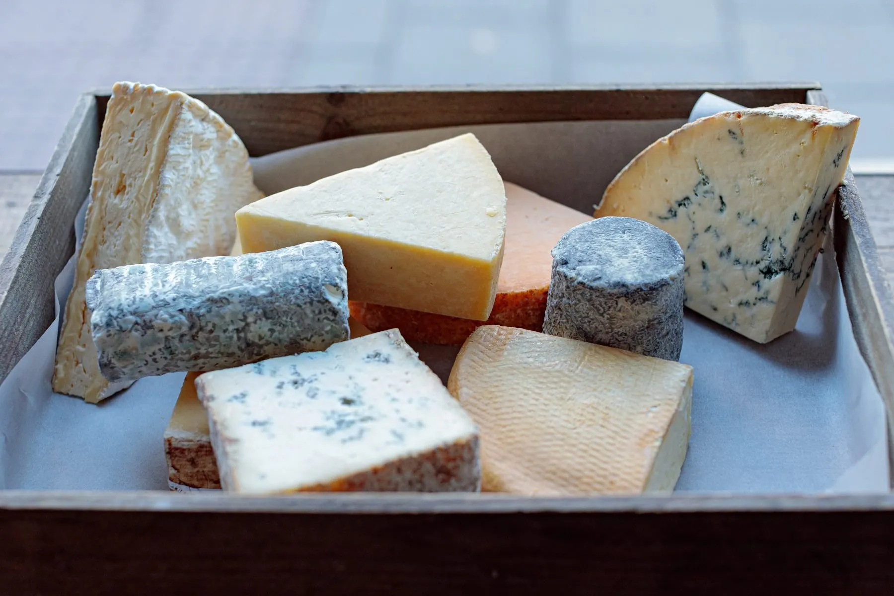 Artisan cheeses in a wooden tray