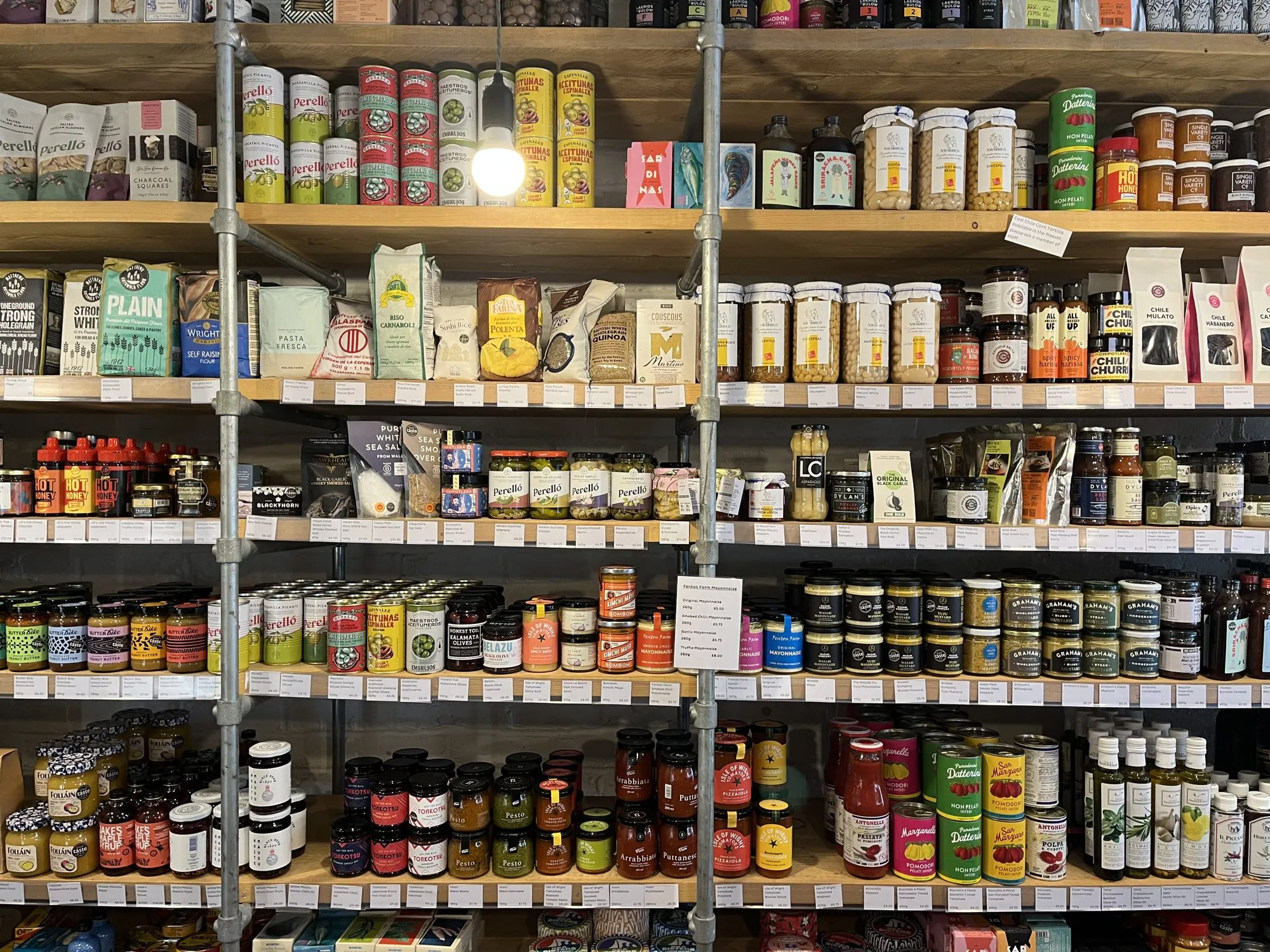 Shelves of jars, tins and packets from small makers on the pantry wall at Found Hope